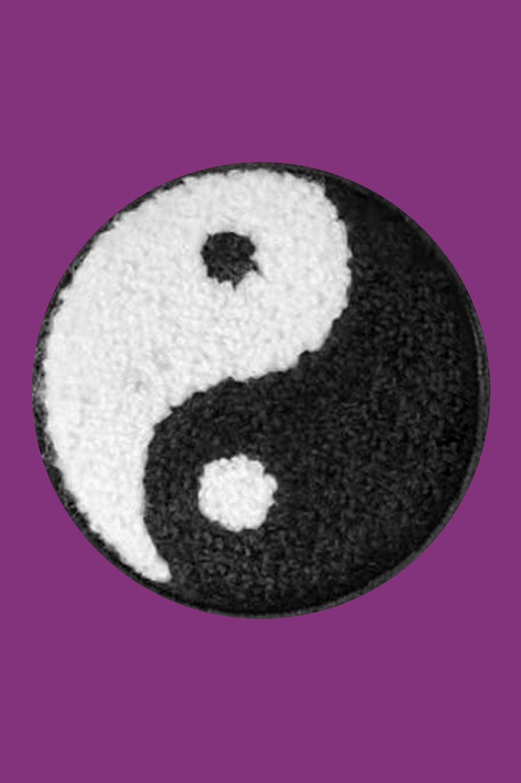Yin and yang symbol on a textured round patch with a purple background