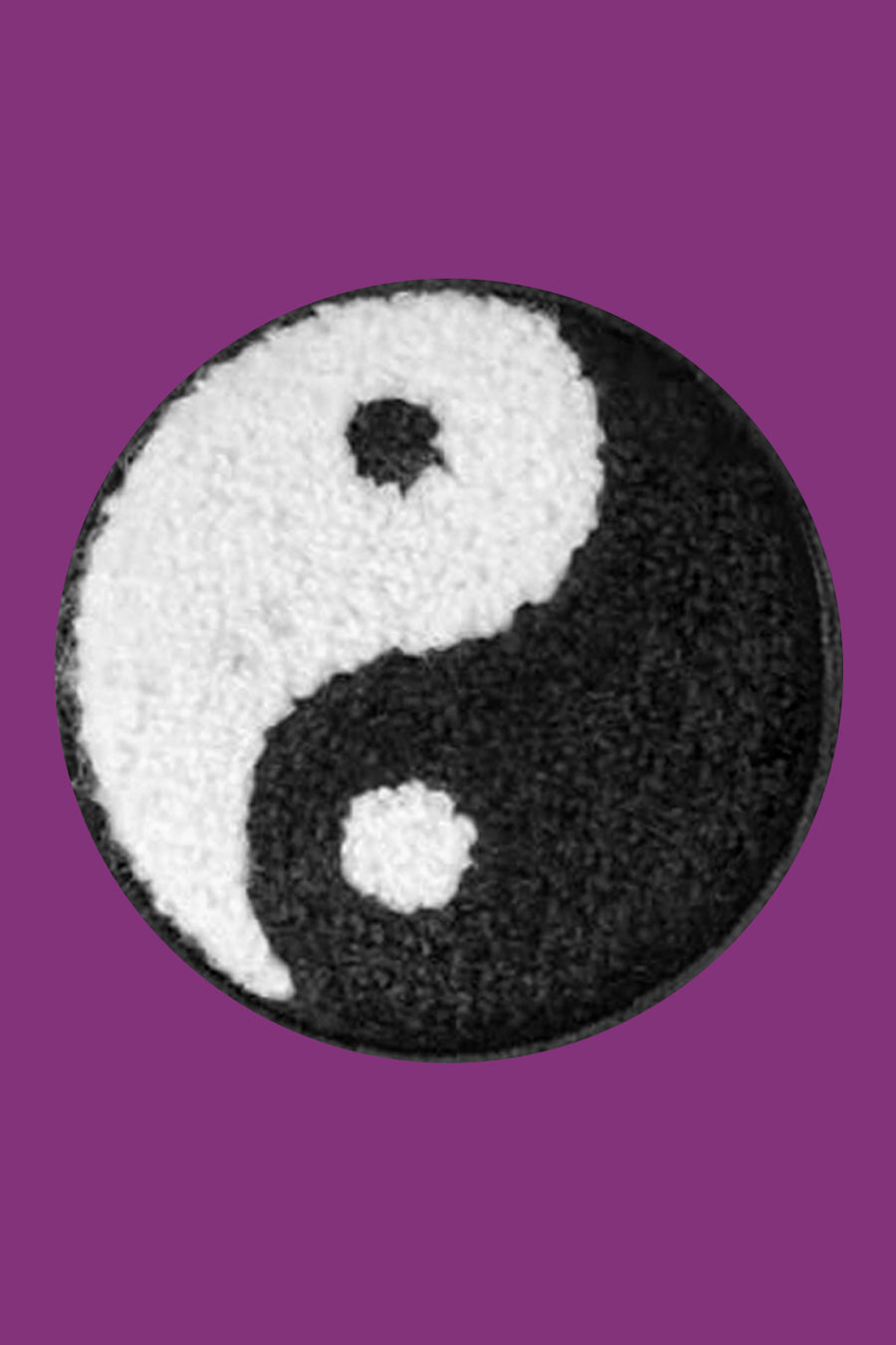 Yin and yang symbol on a textured round patch with a purple background