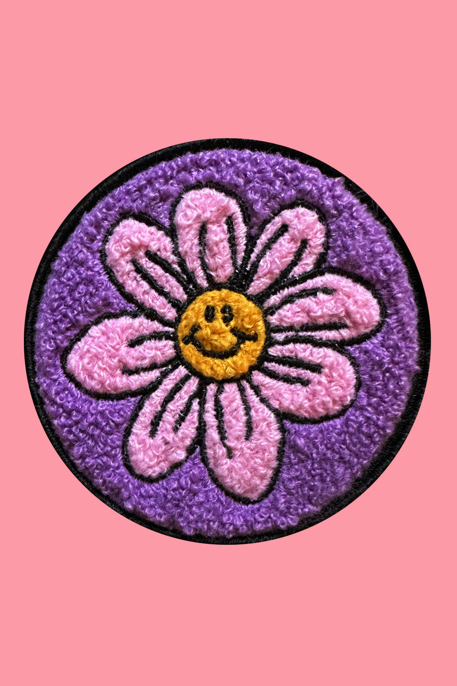 Flower patch with smiley face center on a pink background