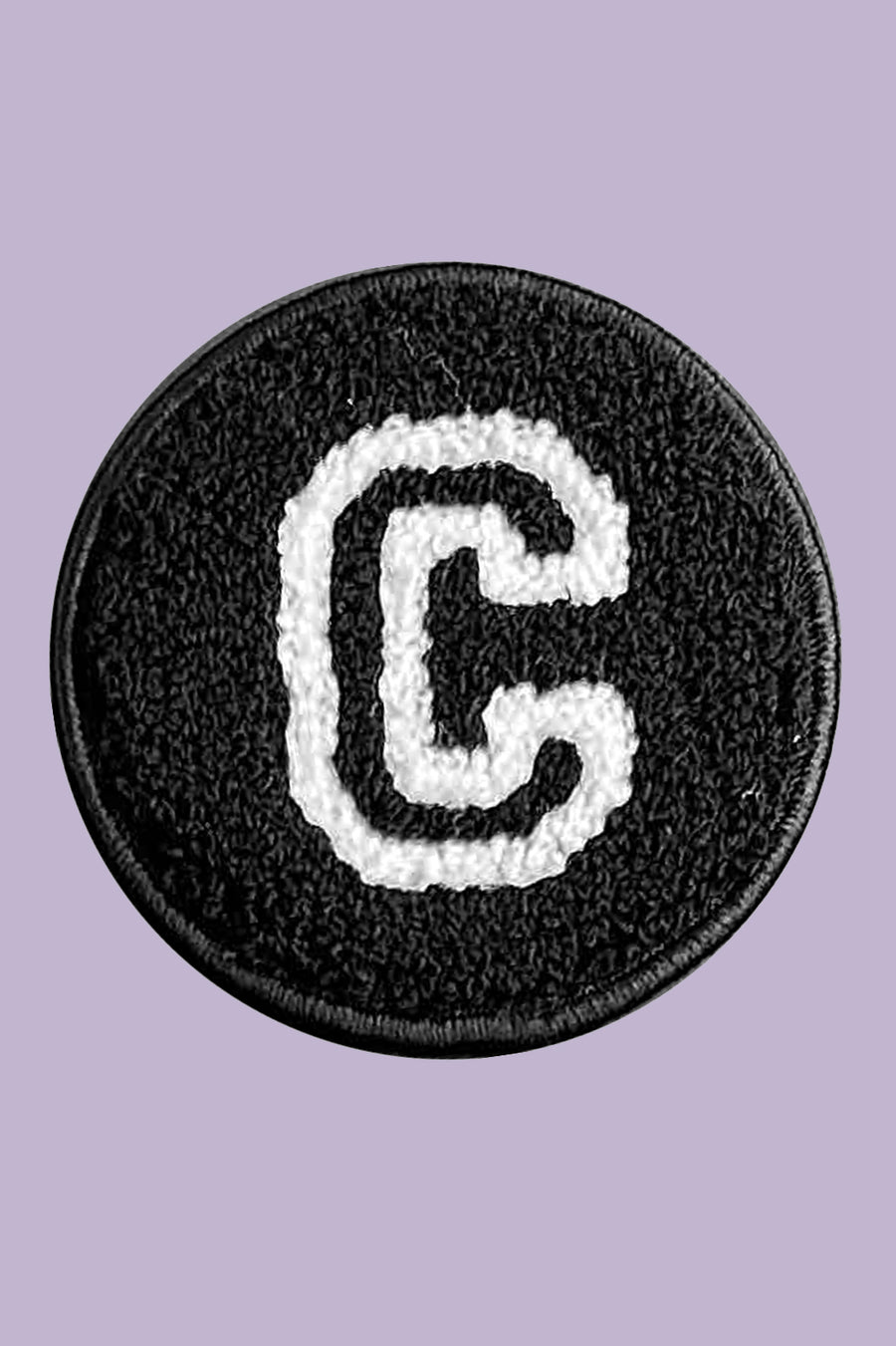 Black circular patch with a white letter 'C' on a purple background