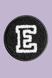 Circular patch with letter 'E' on a purple background