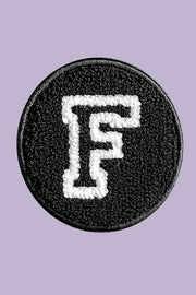 Circular patch with letter 'F' on a purple background