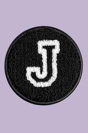 Black patch with white letter 'J' on a purple background