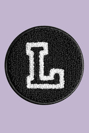Black patch with a white letter 'L' on a purple background