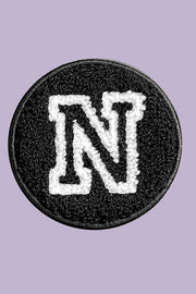 Black patch with white letter 'N' on a purple background