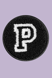 Black patch with white letter 'P' on a purple background
