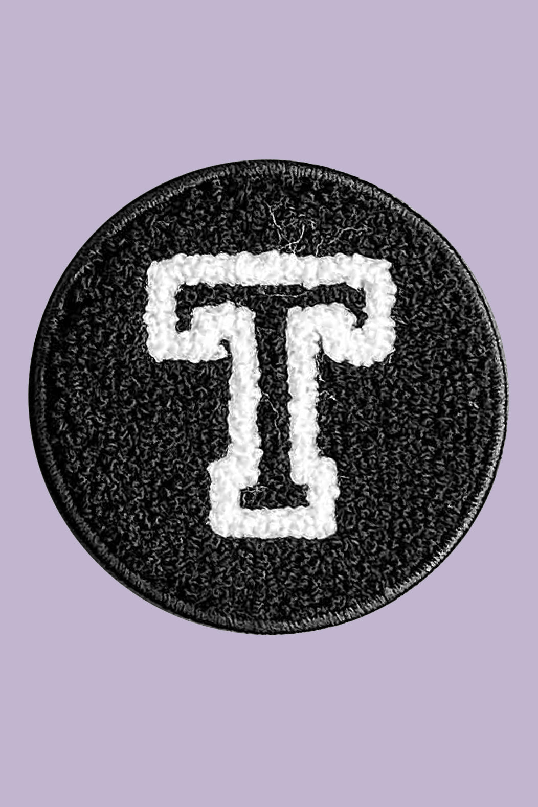 Black patch with white letter 'T' on a purple background