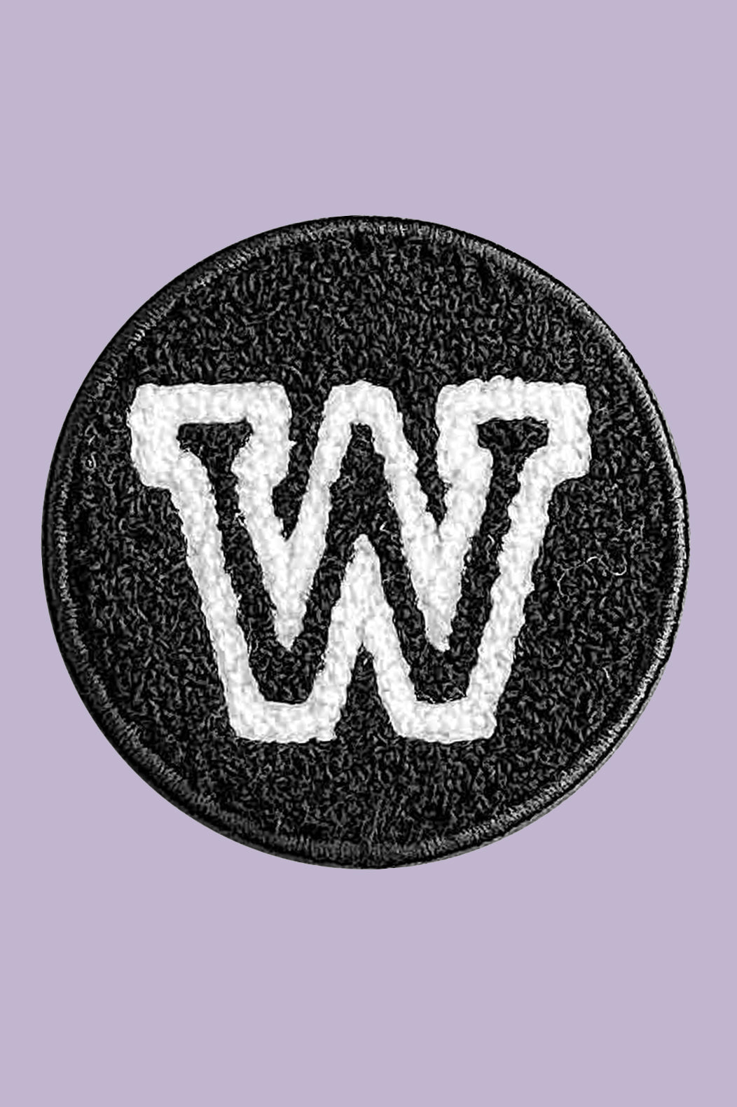 Circular patch with a white 'W' logo on a black border against a purple background