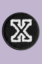 Black and white patch with a symbol on a purple background