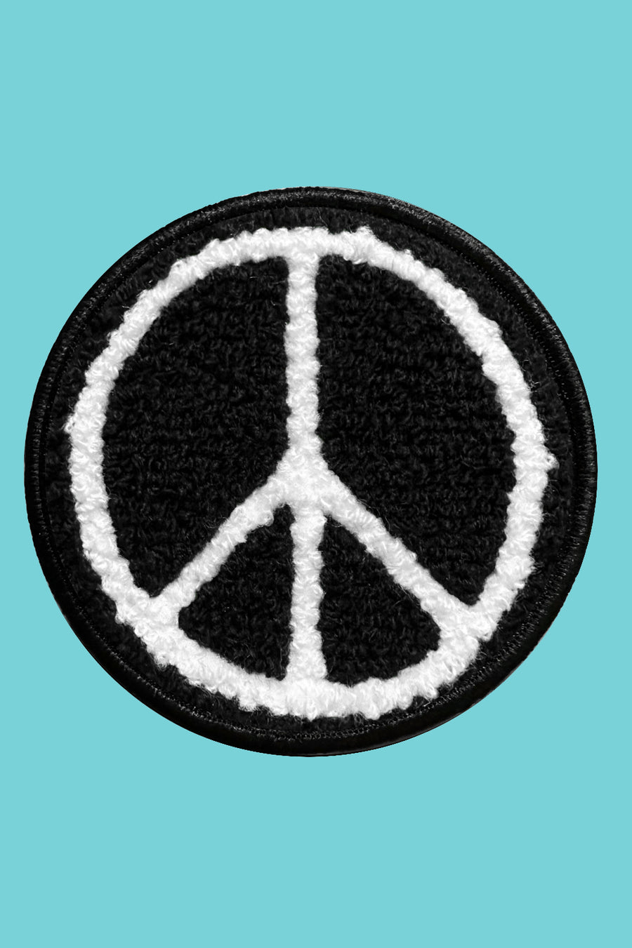 Peace symbol patch on a turquoise background