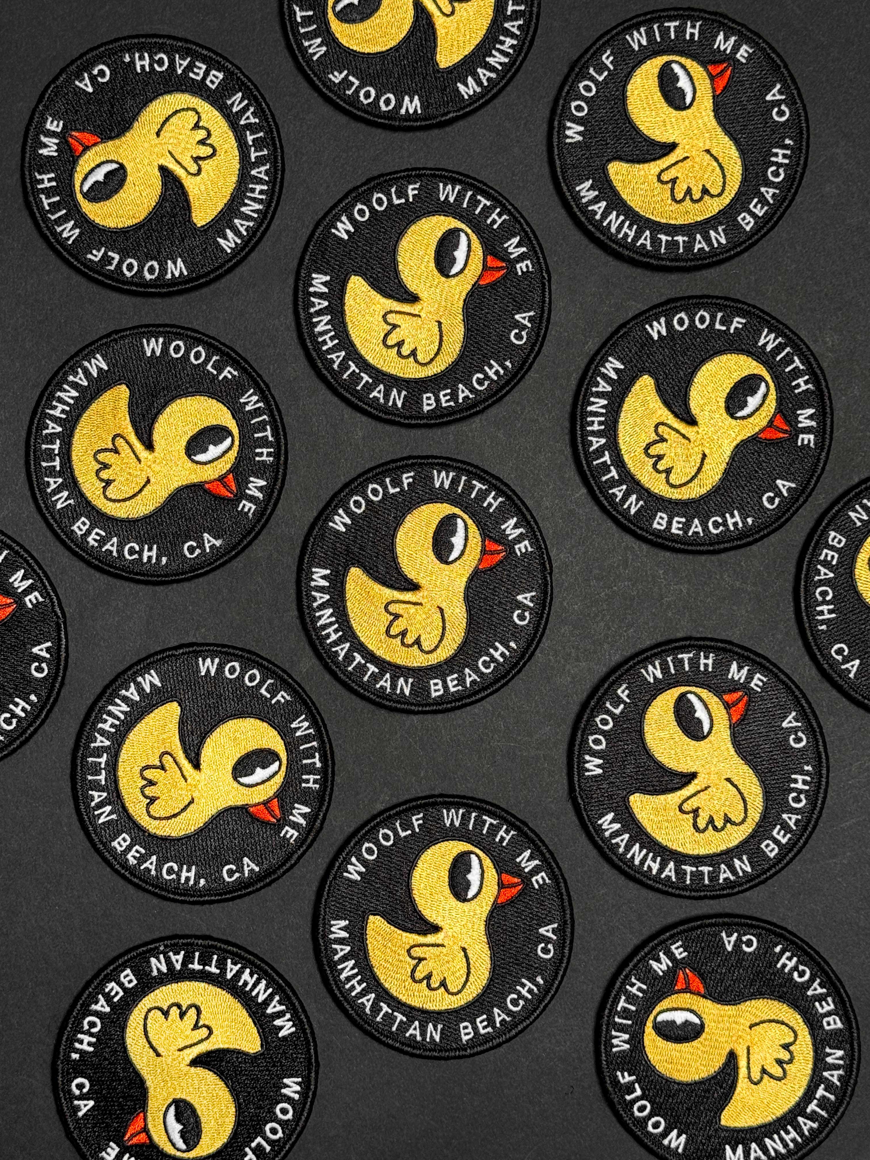 Collection of circular patches with a yellow duck design and text on a black background.