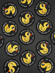 Collection of circular patches with a yellow duck design and text on a black background.