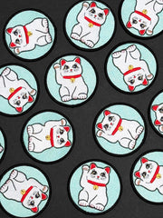Repeating pattern of a white cat with red accents on a black background