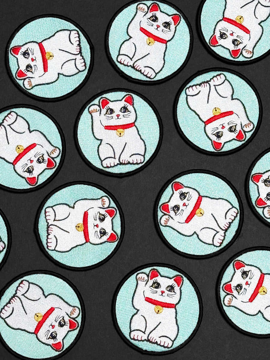 Repeating pattern of a white cat with red accents on a black background