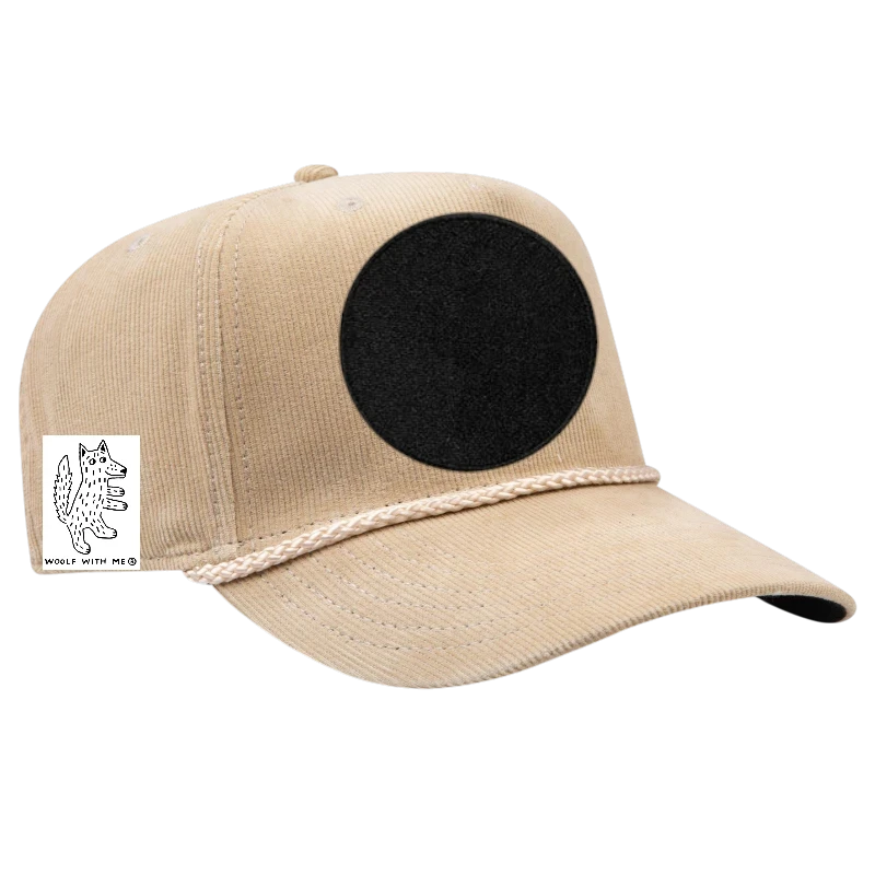 Woolf With Me® tan corduroy baseball cap with black circular patch and embroidered wolf graphic.